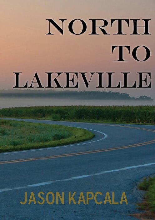 Book cover for North to Lakeville by Jason Kapcala, featuring a twisting road running between fields of grass and a sunset